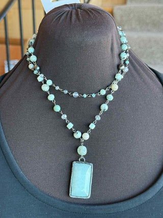 Multi-strand necklace with adjustable lobster claw closure and 2" extension. Each strand is a beaded chain link. The longer strand has a soldered rectangle stone pendant.
Length: 18.5"
Short Strand: 16"
Pendant: 1.5"